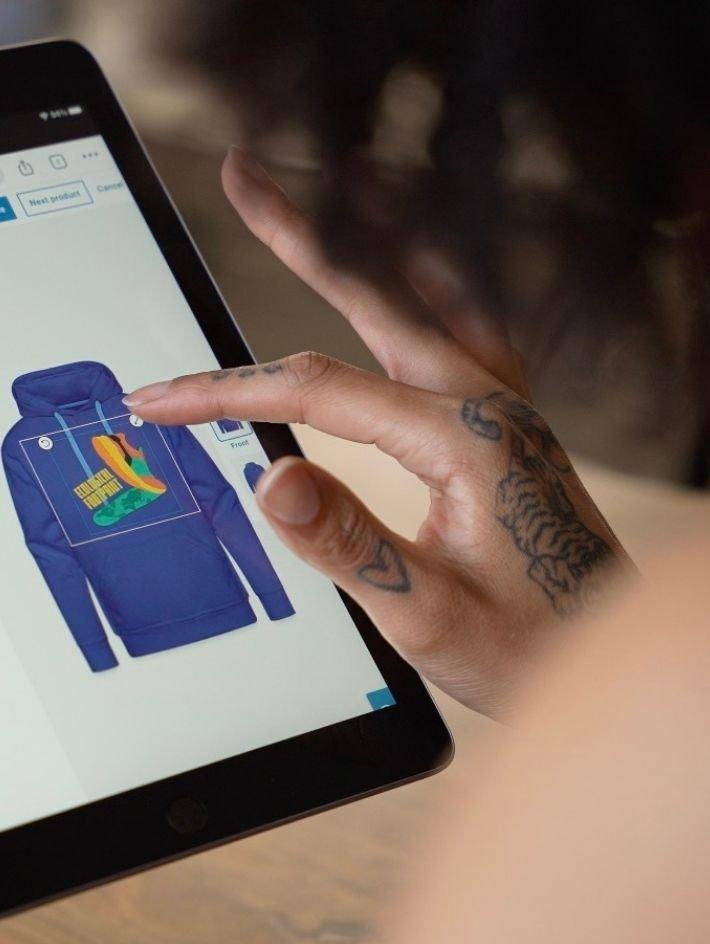 person designing their own custom hoodie using spreadshop