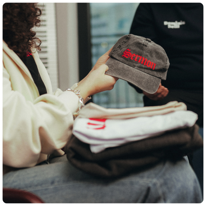 image of a spreadshop user holding their own custom products like hat and t-shirts to show print-on-demand capabilities