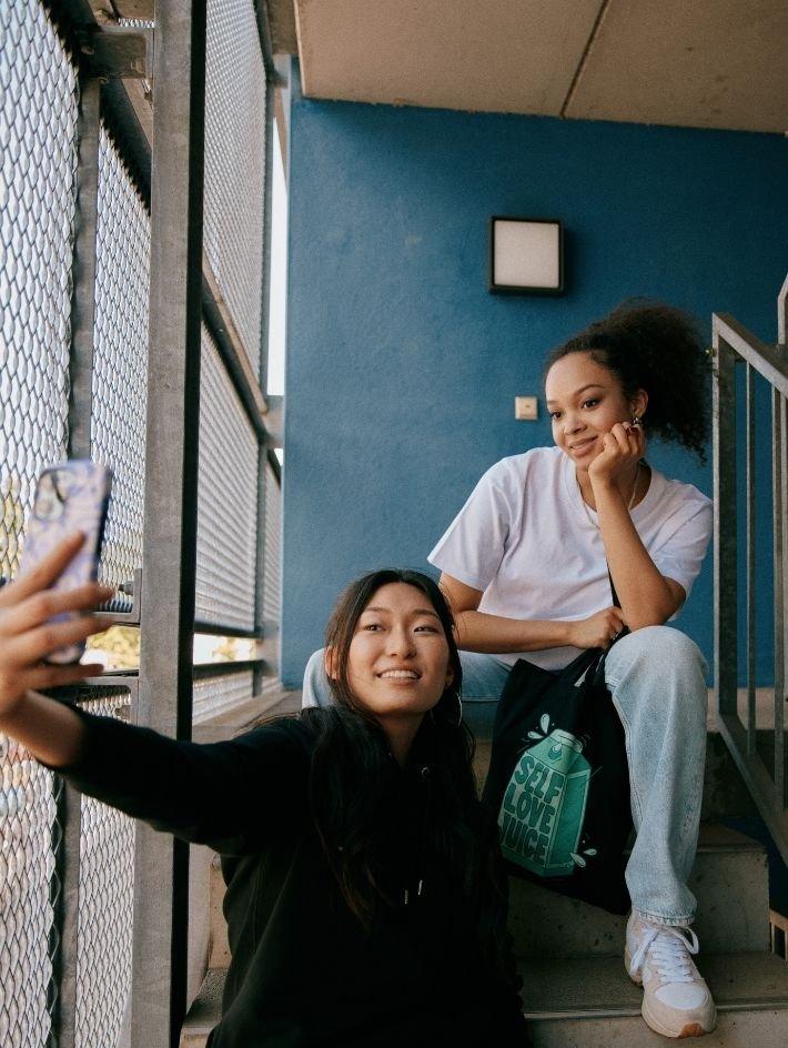 girls promoting their custom printed apparel and tote bag by taking a photo