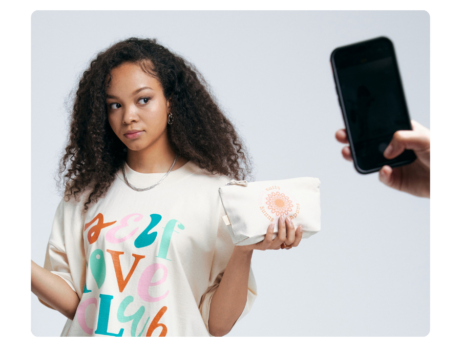 girl wearing custom tshirt and holding custom bag with phone in image to illustrate mobile use