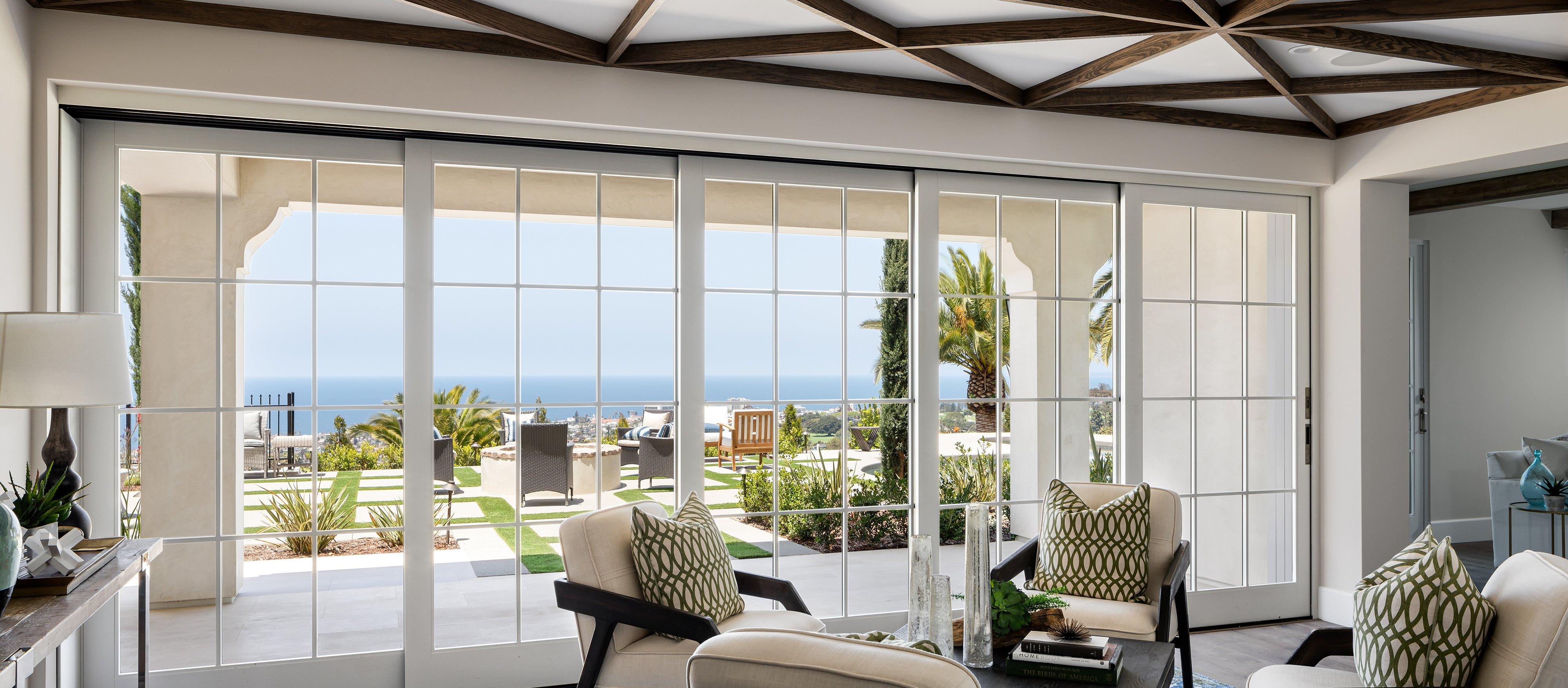 Living area featuring Andersen multi-slide, glass-paneled doors with ocean view.