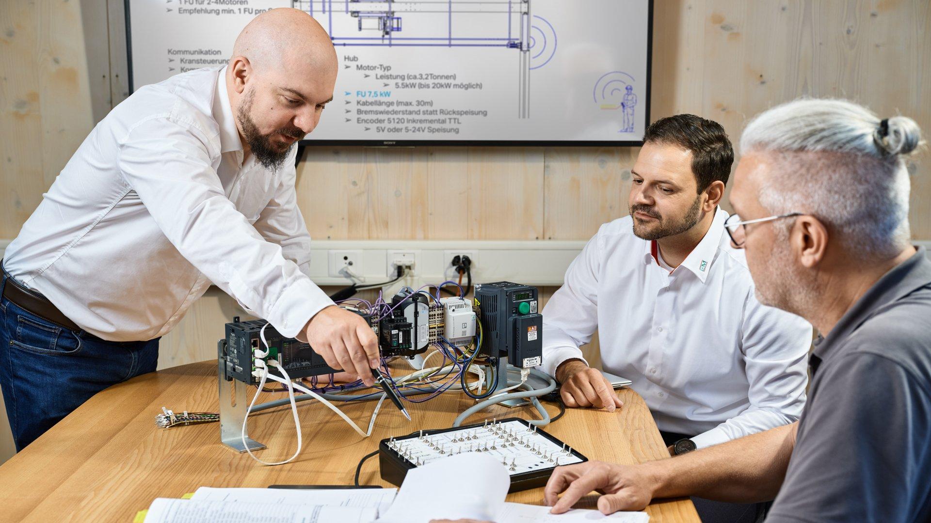Christoph Nef, ingegnere commerciale di EM Industria, Cédric Stucki, Consulente Vendita di EM Industria, e Markus Betschart, Responsabile operativo e di progetto di Hausherr Kranservice SA, in fase di test della struttura di prova (da sinistra a destra)