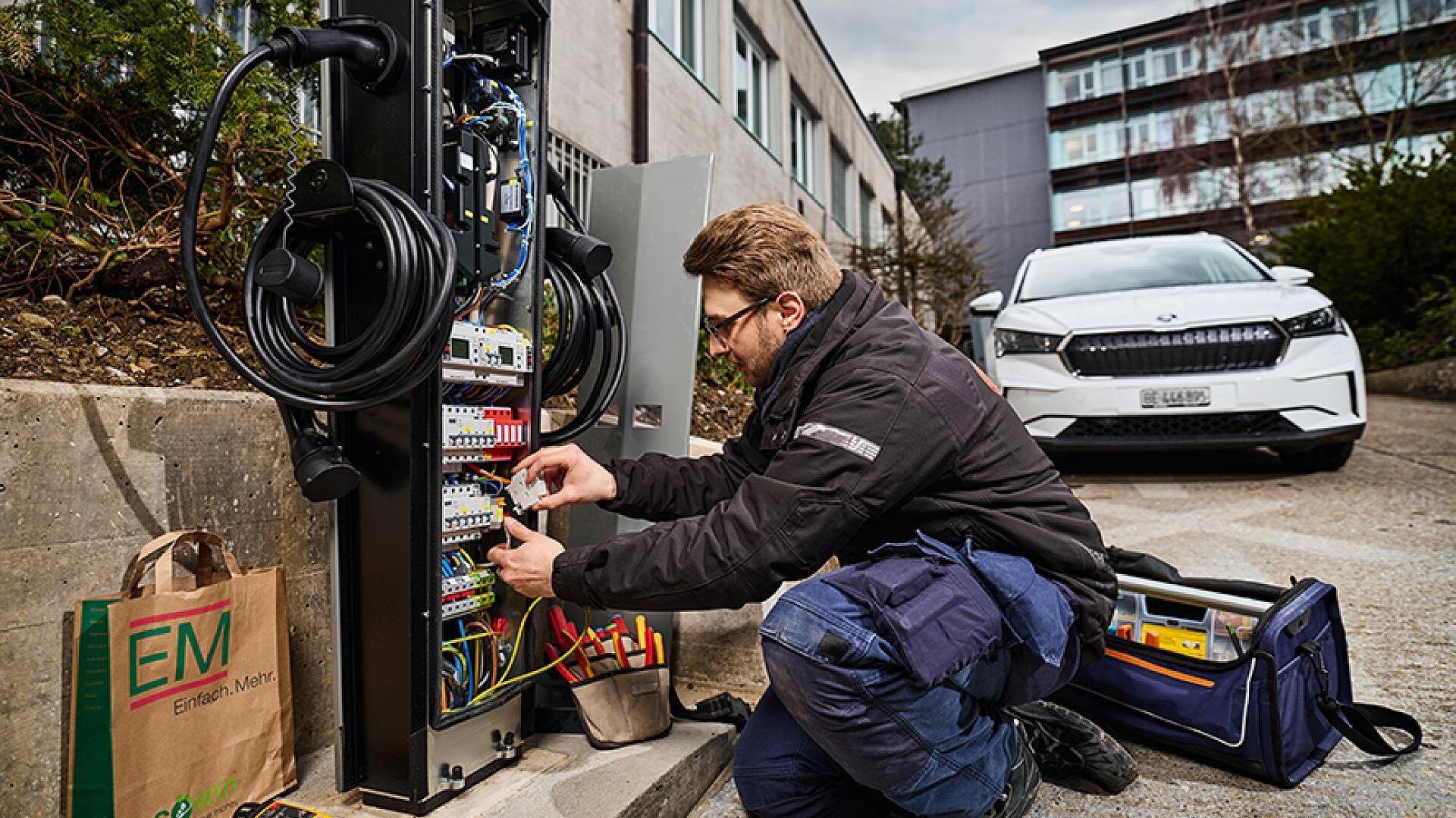 Un esperto di Agel AG installa una delle 11 nuove colonnine di ricarica doppie per i veicoli elettrici dell’Ufficio federale di topografia swisstopo a Berna.