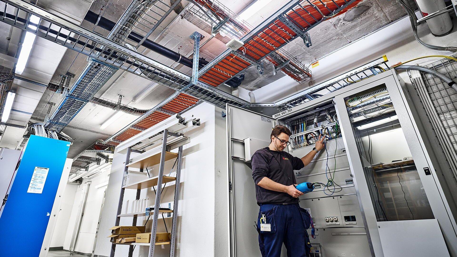 Verifica del cablaggio del distributore secondario per garantire la distribuzione di corrente alle stazioni di ricarica nell’ampio sito di swisstopo. Nel seminterrato sono state incorporate nel soffitto delle condotte aggiuntive per alloggiare le grandi sezioni di cavo.