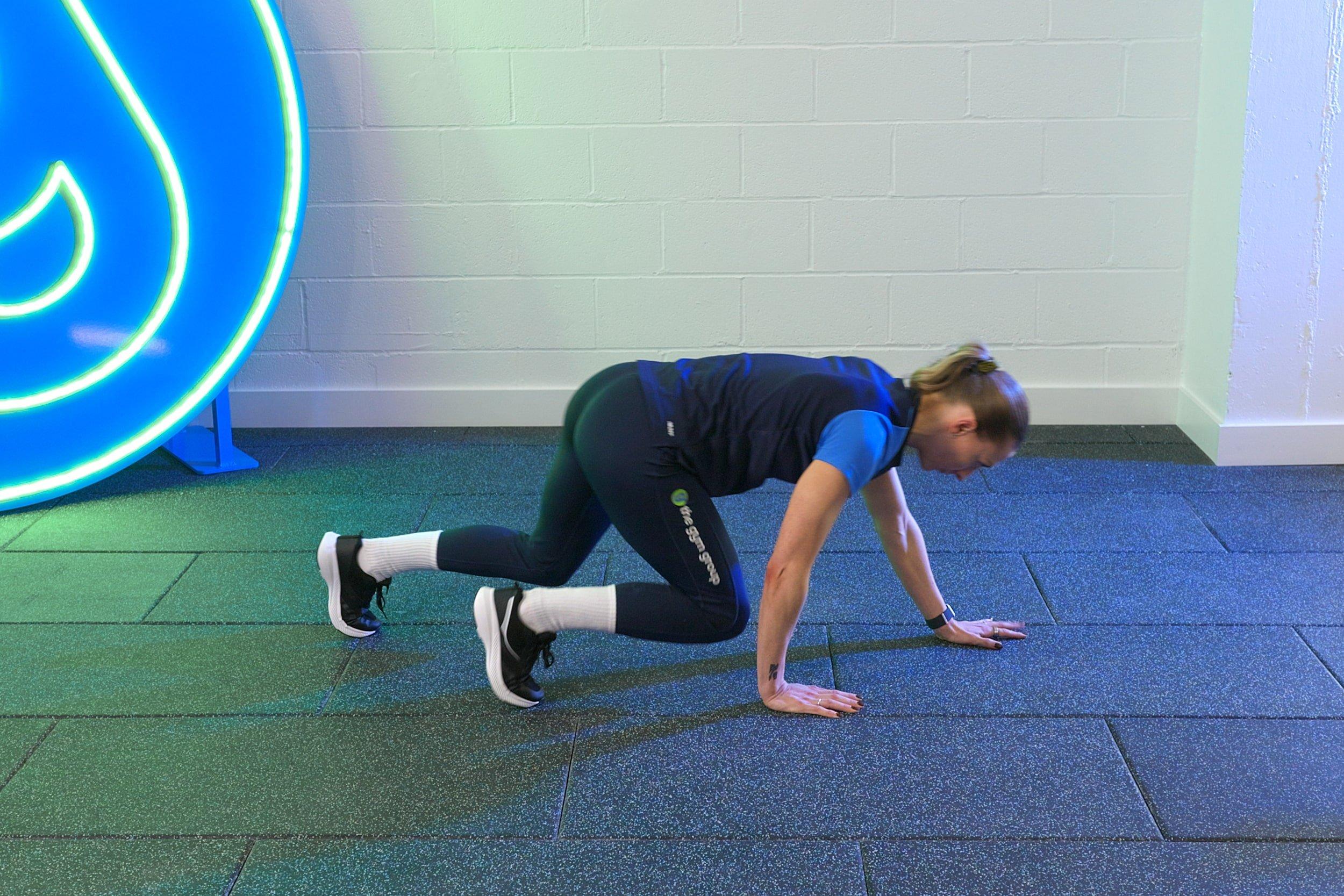 Gym Trainer demonstrating how to do a Bear Crawl.