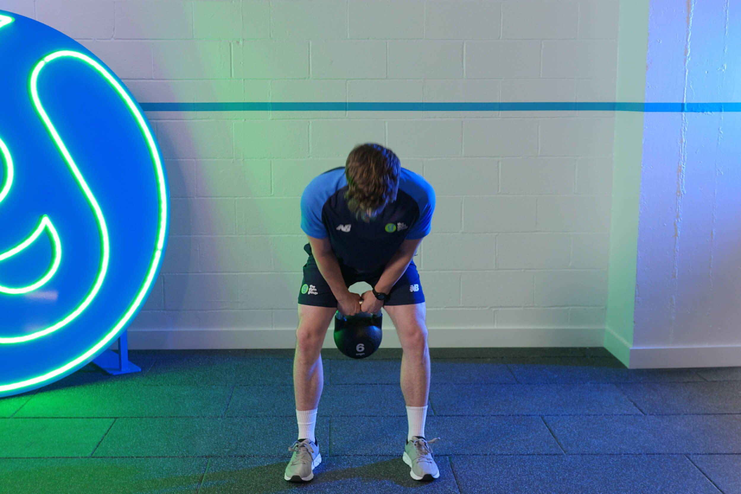 member doing kettlebell swings