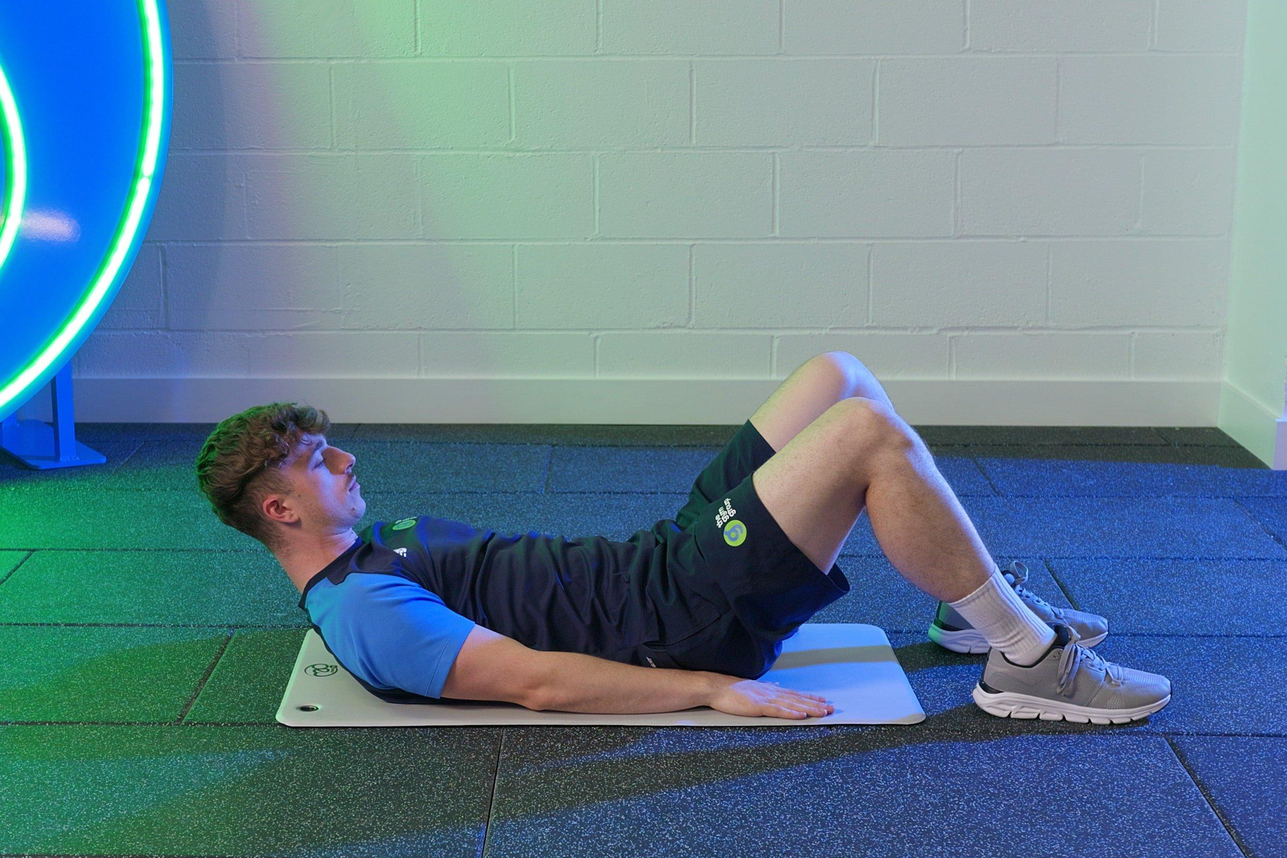 Personal trainer in the starting position for a sit up.