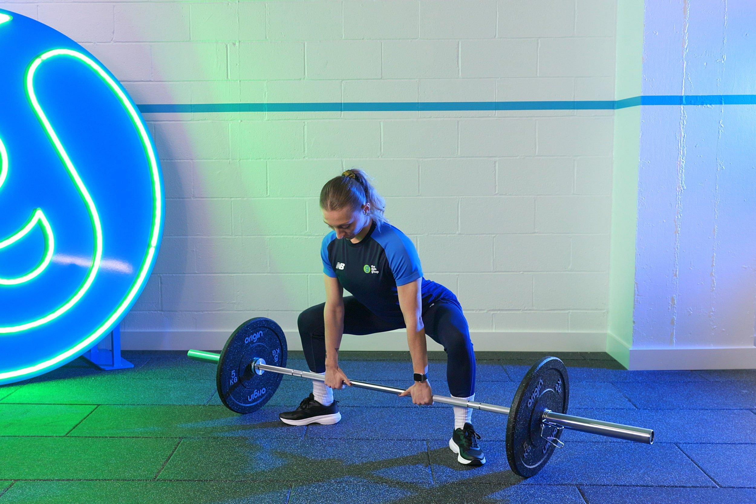 gym member doing sumo deadlifts