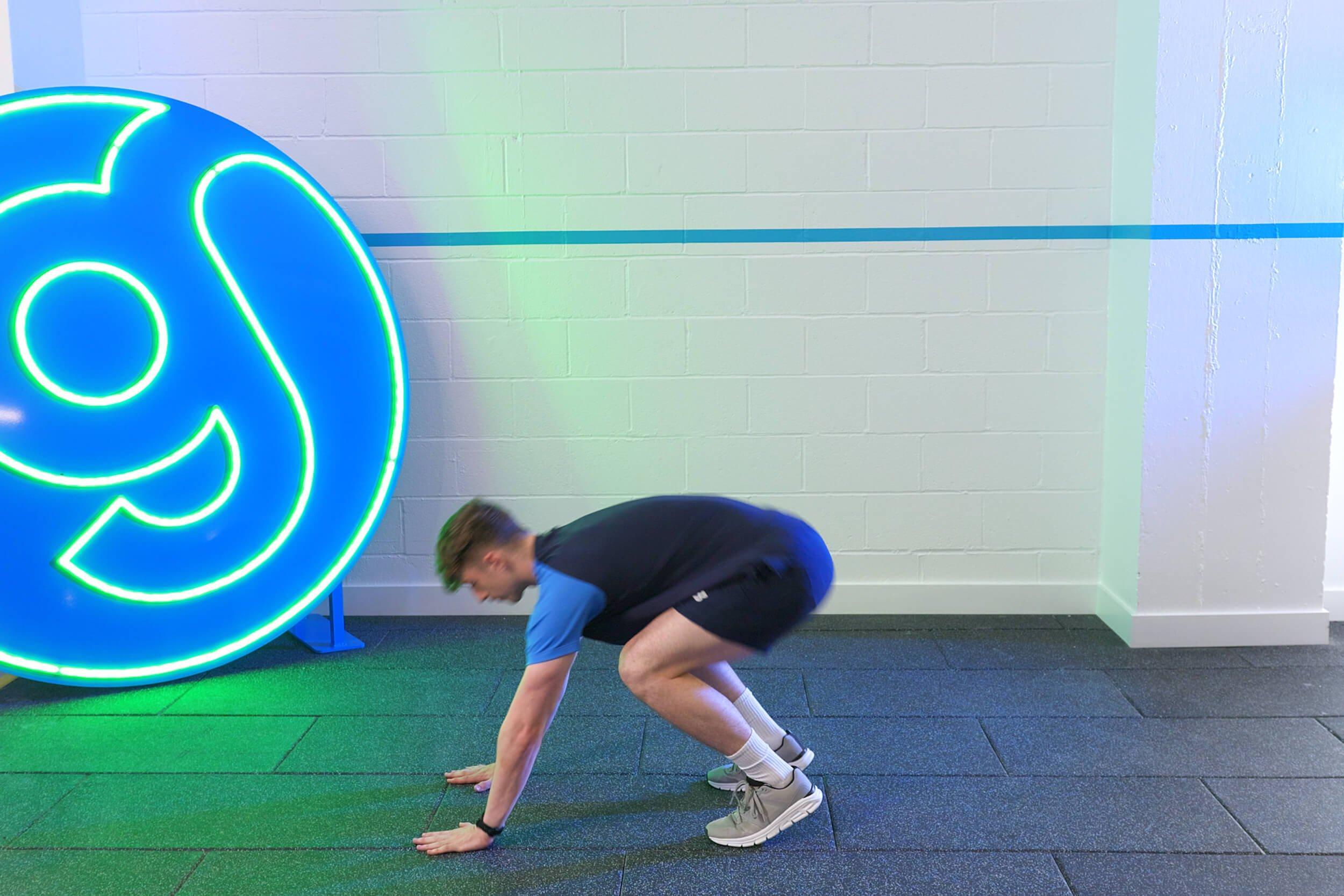 Personal trainer demonstrating burpees.