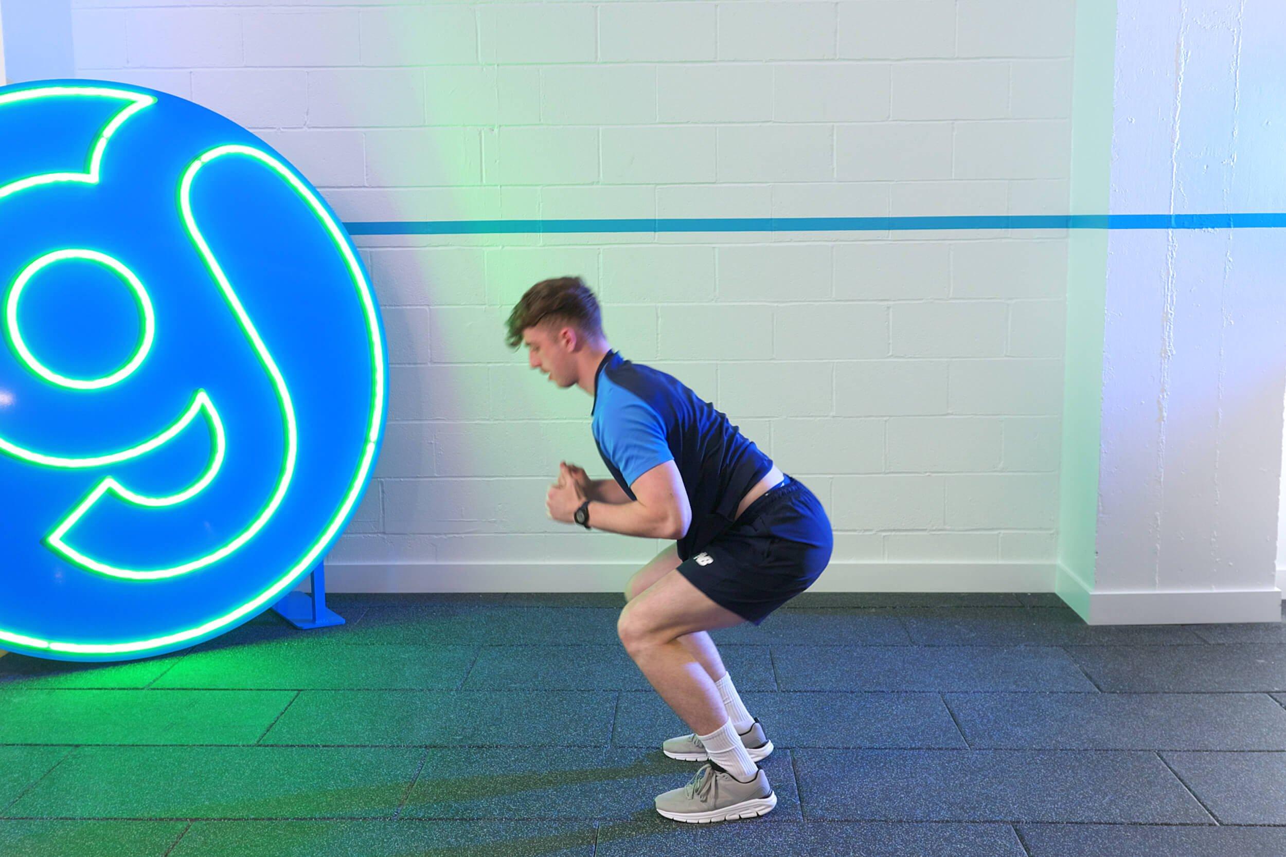 Gym staff demonstrating how to do burpees.