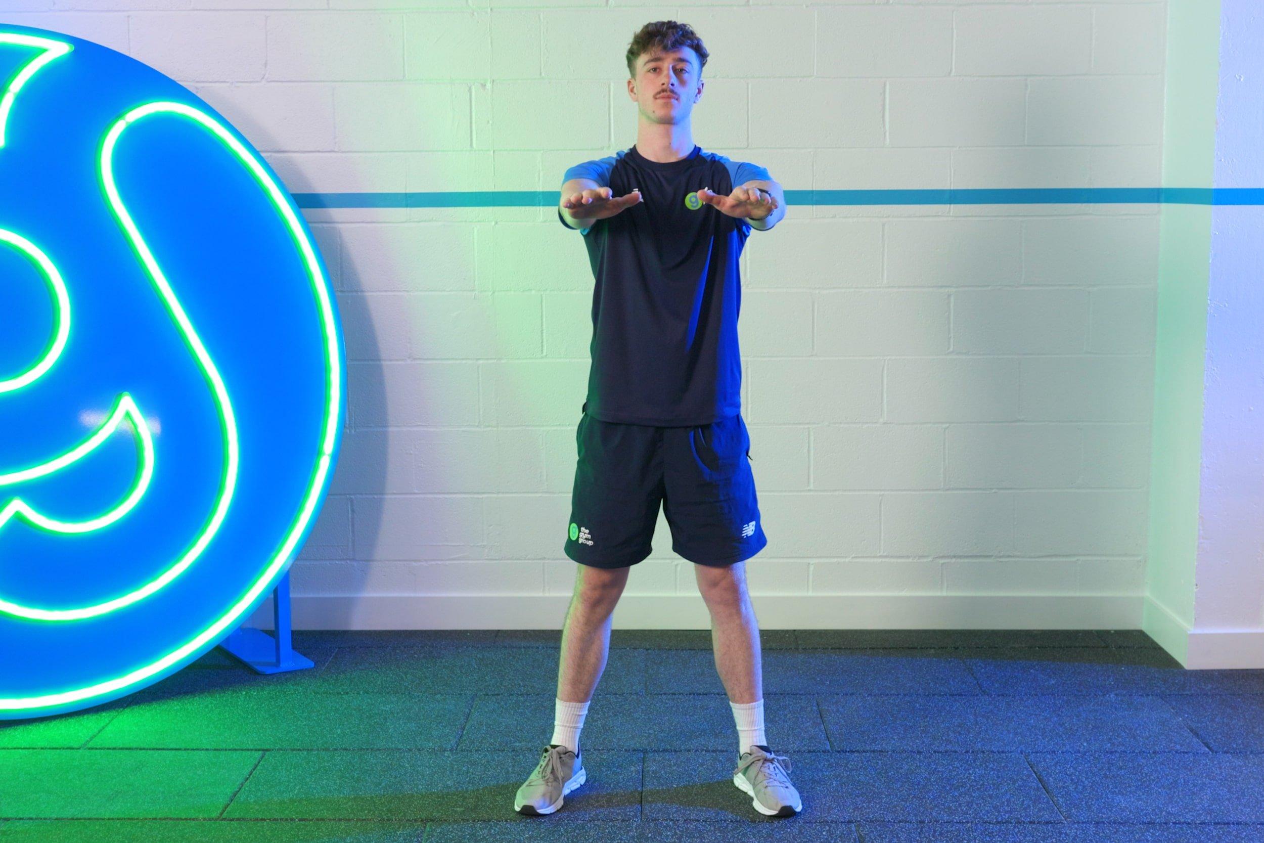 Gym member doing squats on a mat