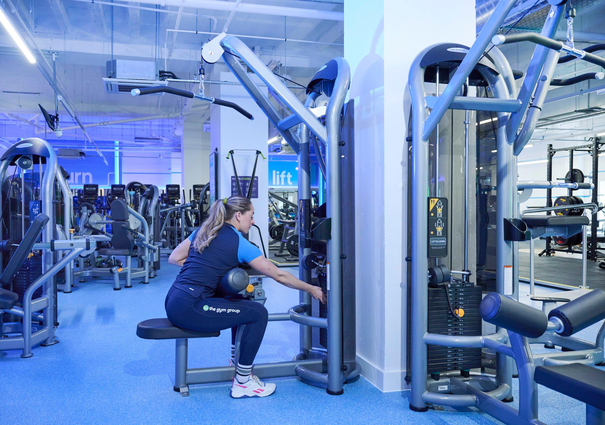 Gym member using the pin loaded lat pulldown machine