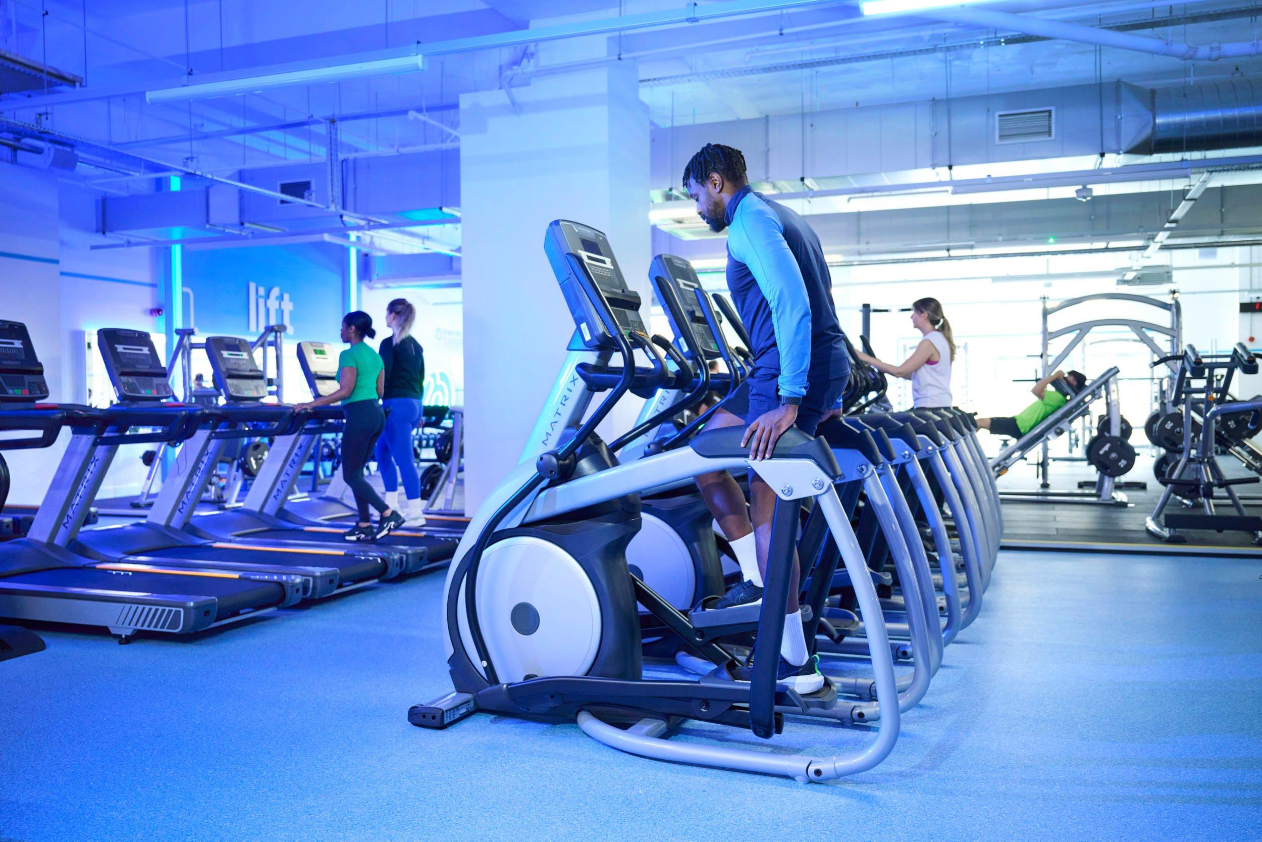 Gym goer stepping on the elliptical machine