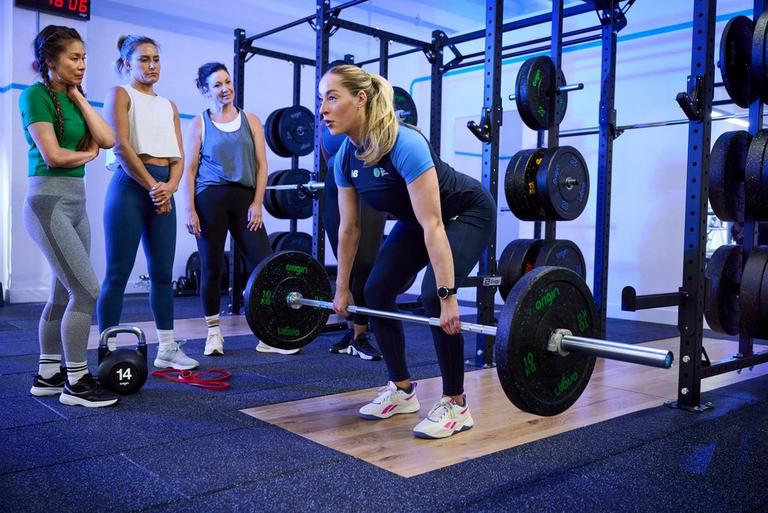 Member using the weight sled with a personal trainer
