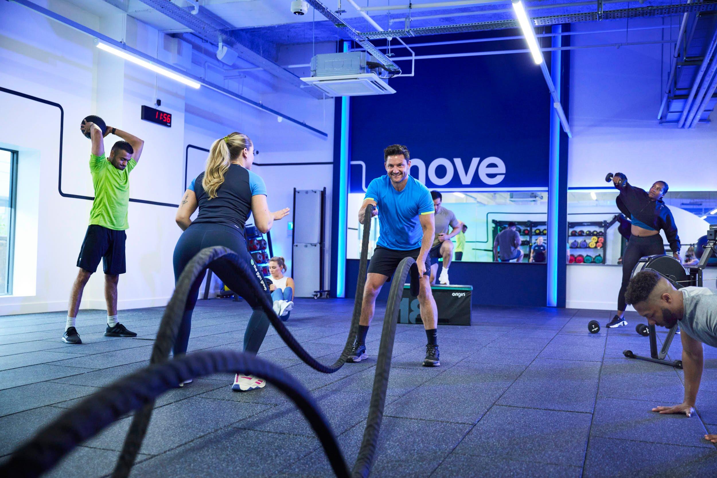 Members doing rope slams in the gym at a cardio class
