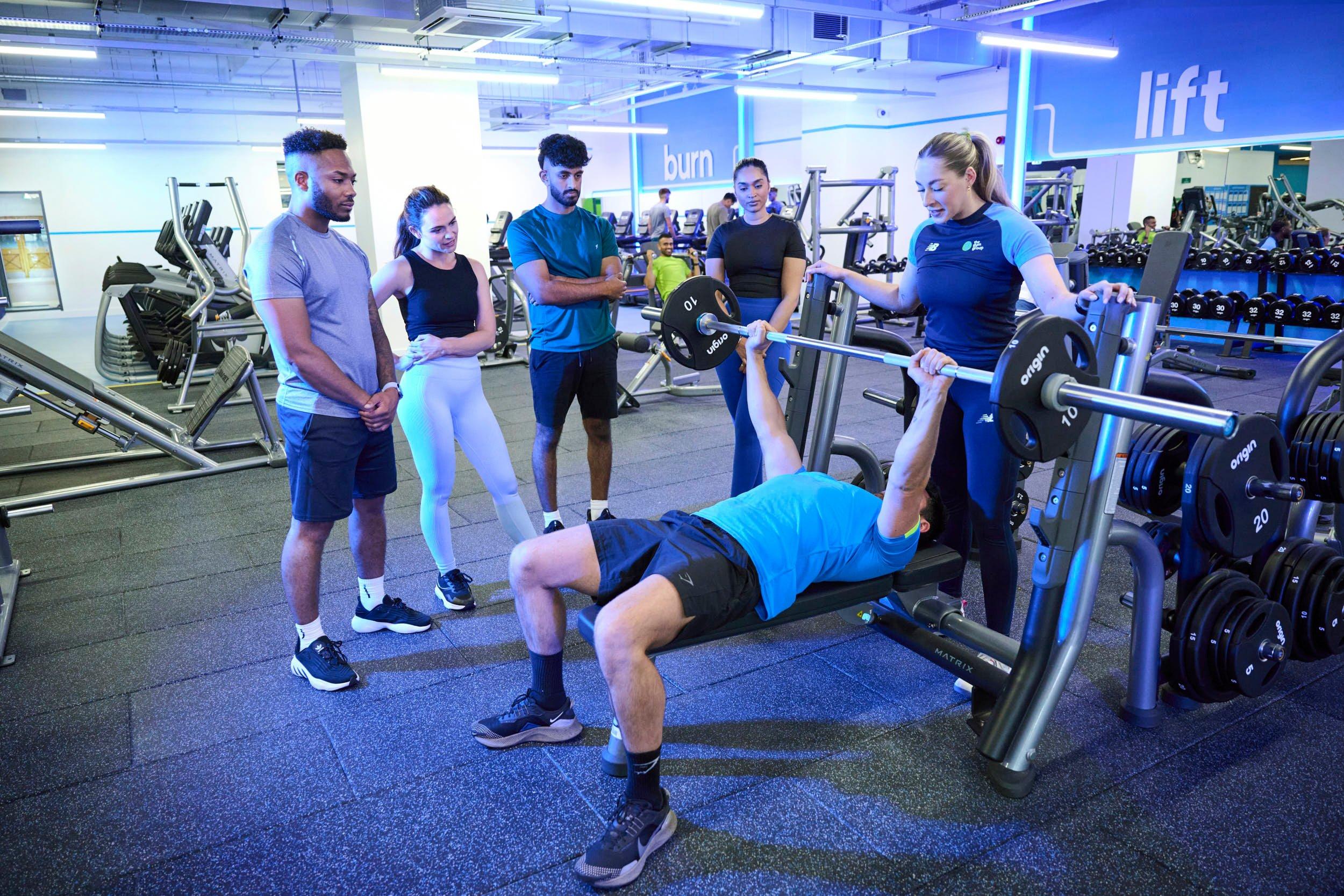 Personal trainer teaching how to perform bench press safely