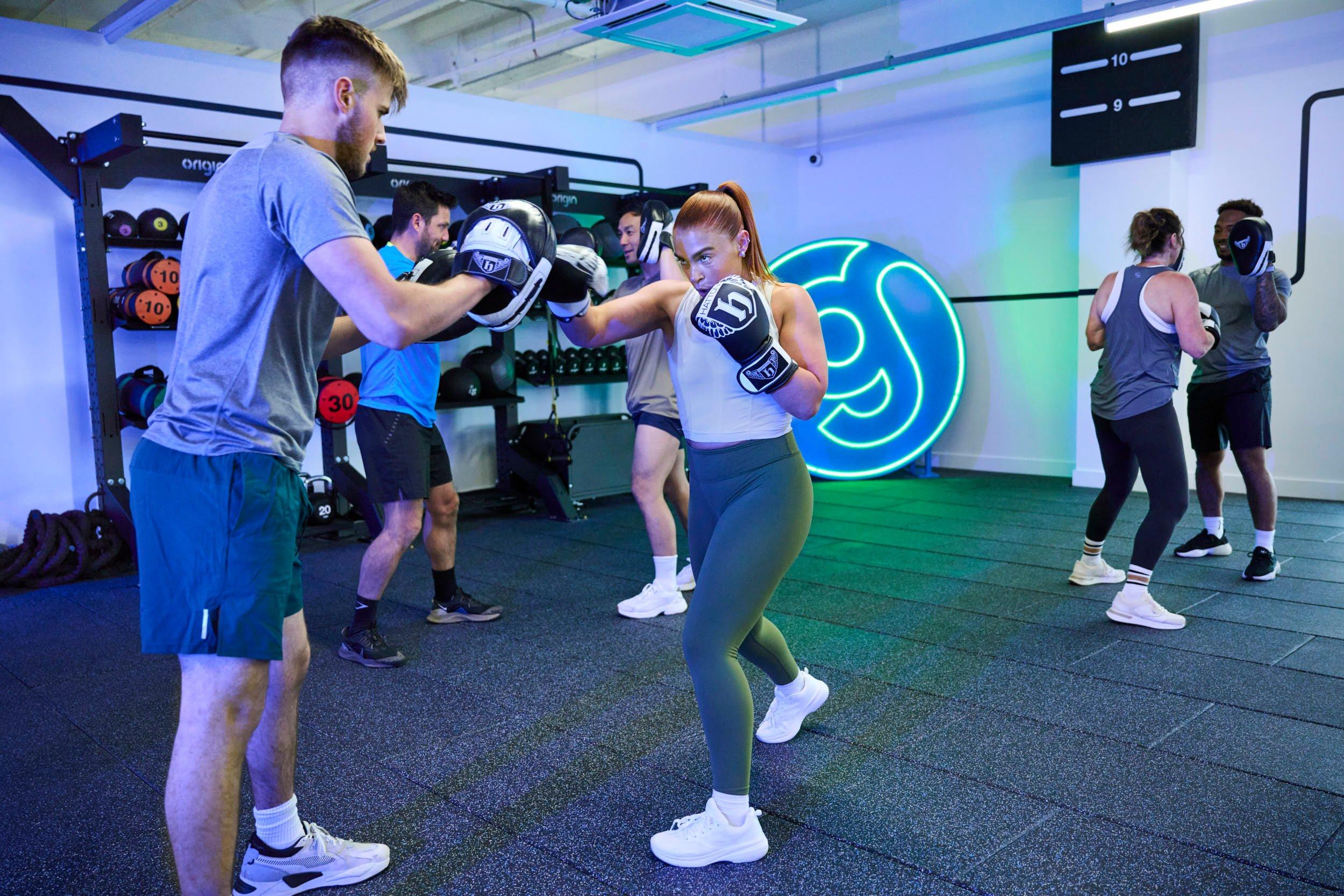 members throwing punches at a gym boxing class