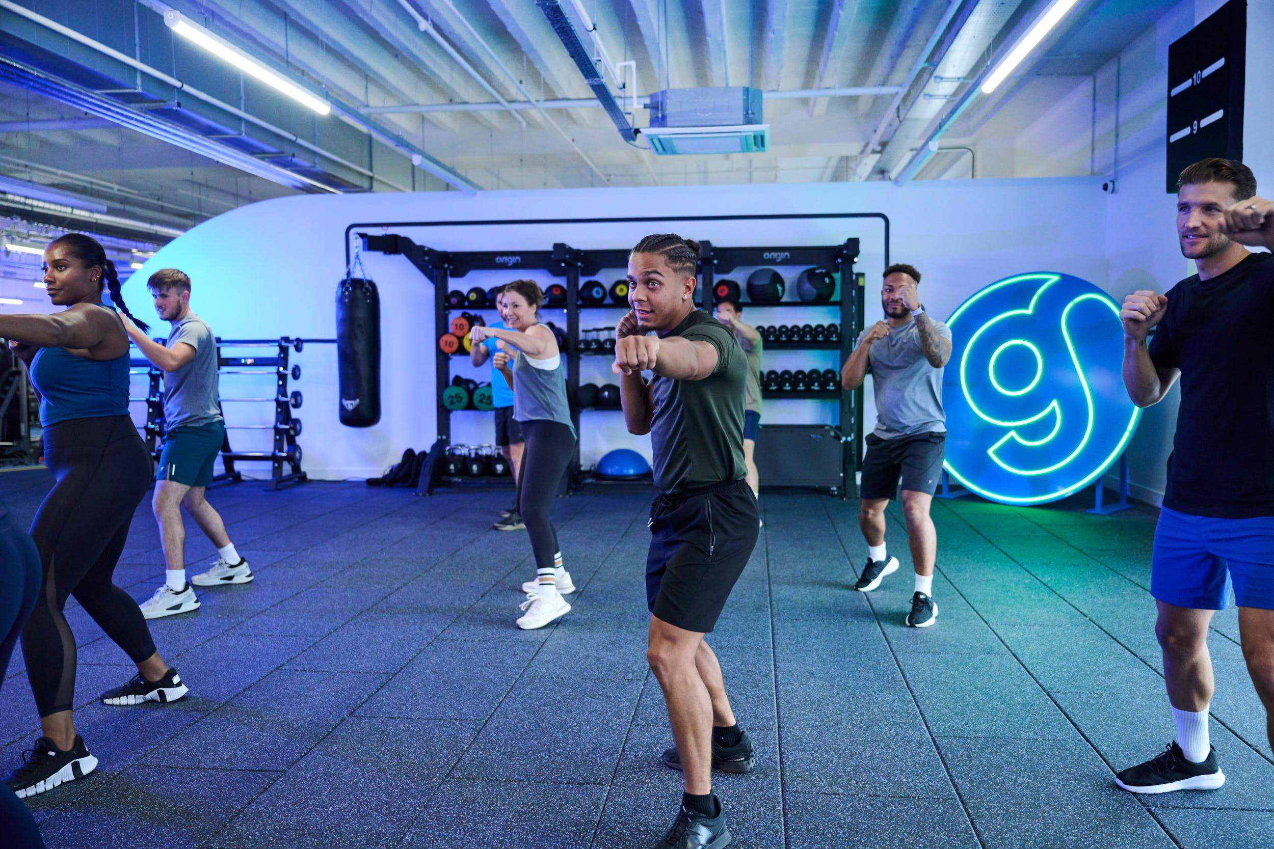 Gym members doing a boxing gym workout in a group exercise class.