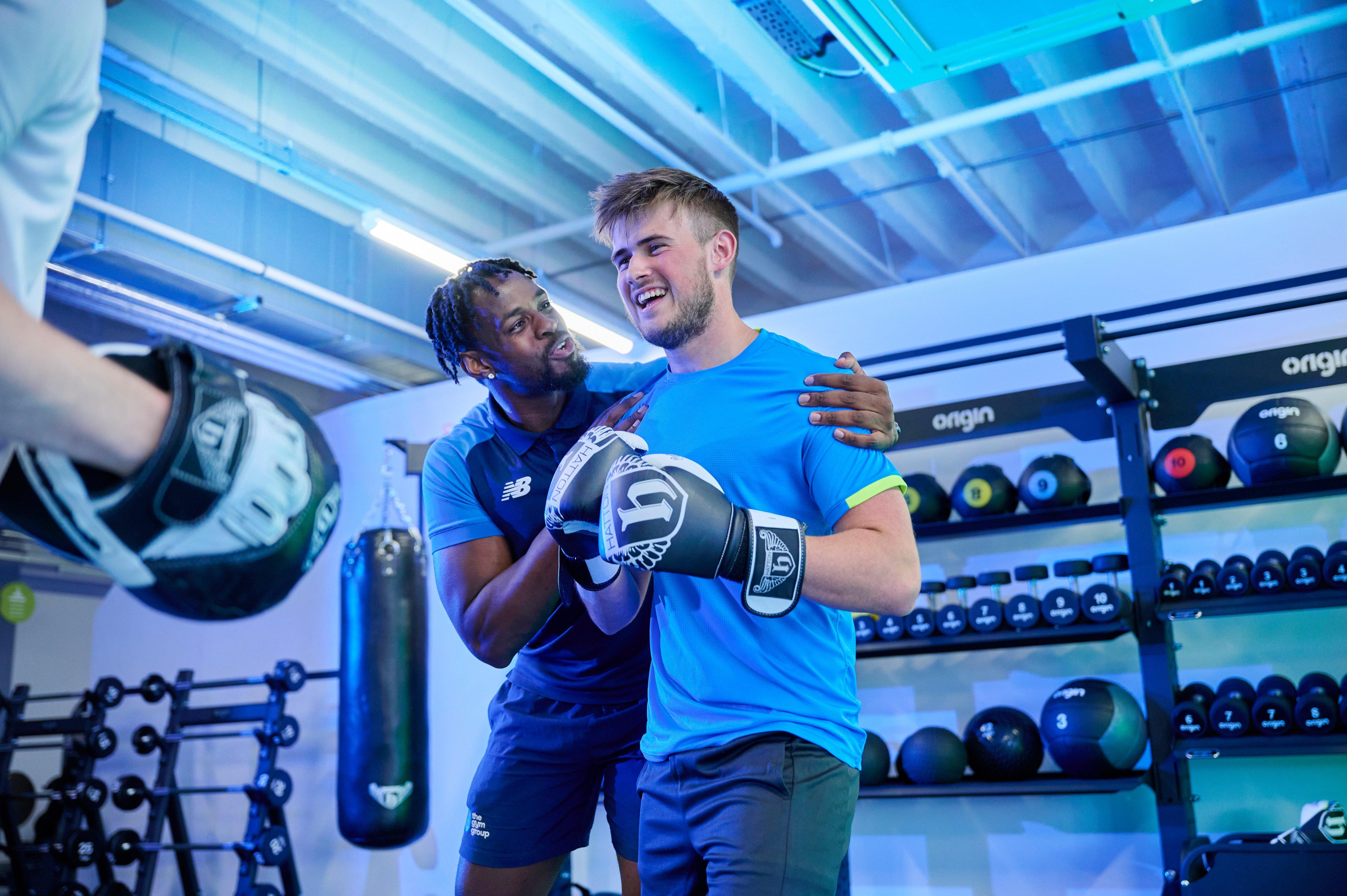 Two gym members laughing together after a workout.