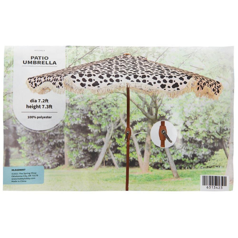 blue print patio umbrella 'The Chaya' Printed and Orange Tassel Bali Parasol the canopy features a vibrant Black & Ivory Cow Print